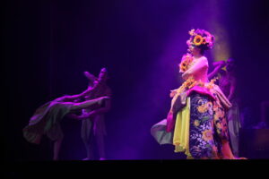 foto di scena dal palco di OGR Torino: cantante in costume con luci rosa