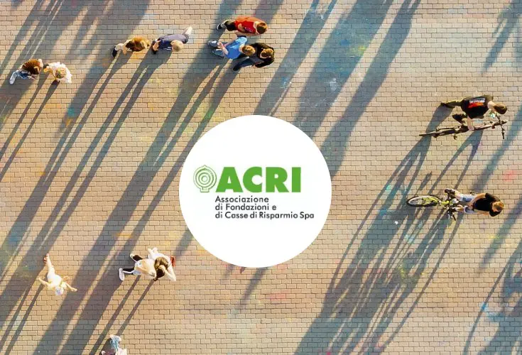 logo acri su immagine dall'alto di persone in una piazza al tramonto