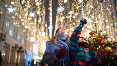 Little boy with his mother buying tera and sweets at a Christmas market
