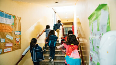 Rear view of a group of elementary age students going to class