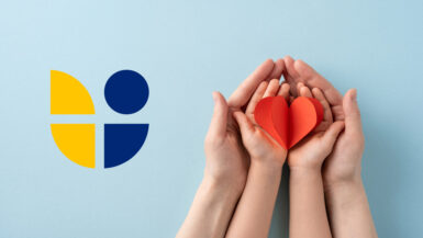 Image depicting adult and child hands holding a red heart, representing love, care, and family bonds